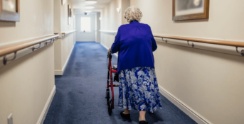 An older woman with a walker in a nursing home