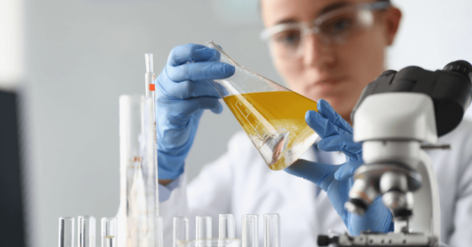 A scientist examines chemicals in a flask